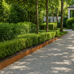 Beeteinfassung aus Cortenstahl entlang eines Kieswegs im Park
