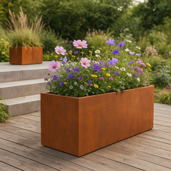 Pflanzkübel aus Cortenstahl mit blühenden Stauden auf Holzterrasse