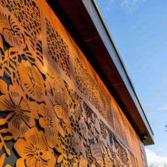 Sichtschutz aus Cortenstahl mit floralem Lasermotiv an Gebäude