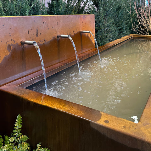 Wasserbecken aus Cortenstahl mit drei Wasserausläufen im Garten
