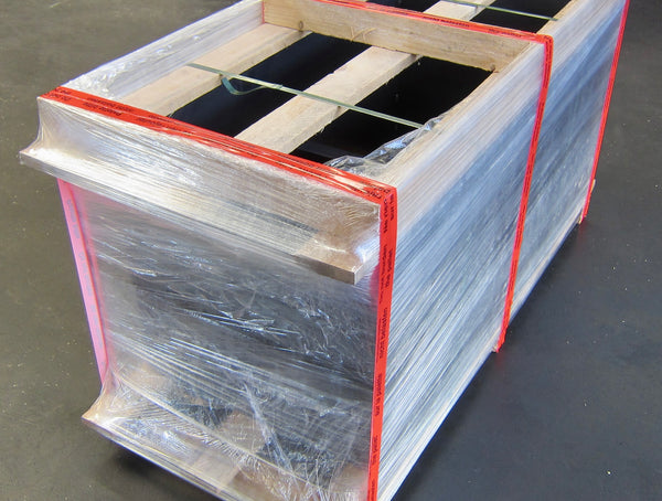 In Folie verpackte Warenpalette mit Holzrahmen und Spanngurten